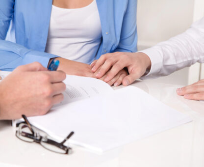 close-up of hands reviewing and signing estate planning documents during a trust consultation, illustrating irrevocable vs revocable trust considerations.