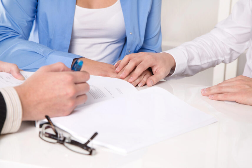close-up of hands reviewing and signing estate planning documents during a trust consultation, illustrating irrevocable vs revocable trust considerations.