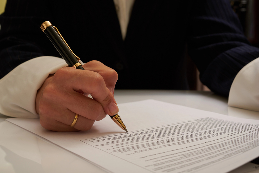 signing a legal document during the probate process, illustrating how long does probate take in california 