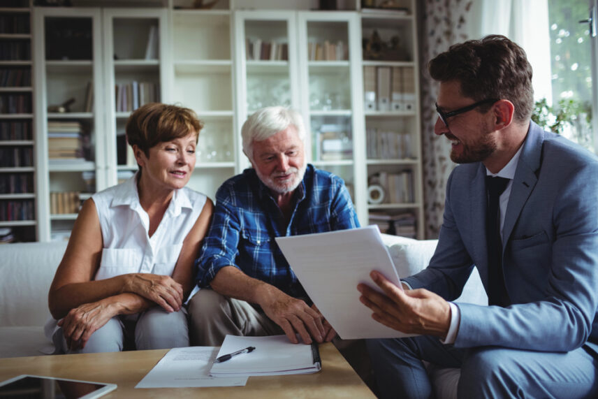 estate planning attorney reviewing legal documents with an older couple in their home