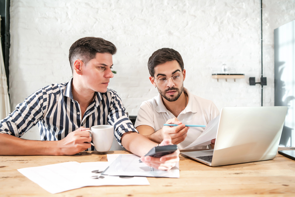 gay couple looking over paperwork to emphasize the importance of how to choose an estate planning attorney