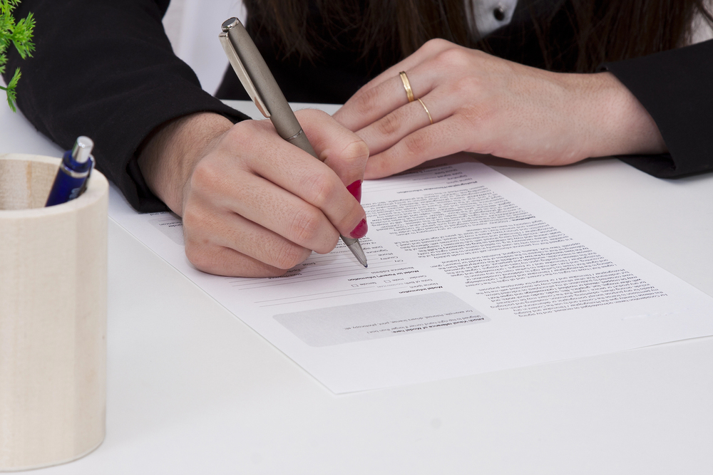 woman signing trustee documents