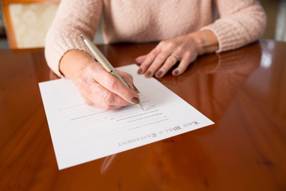 woman signing last will and testament documents