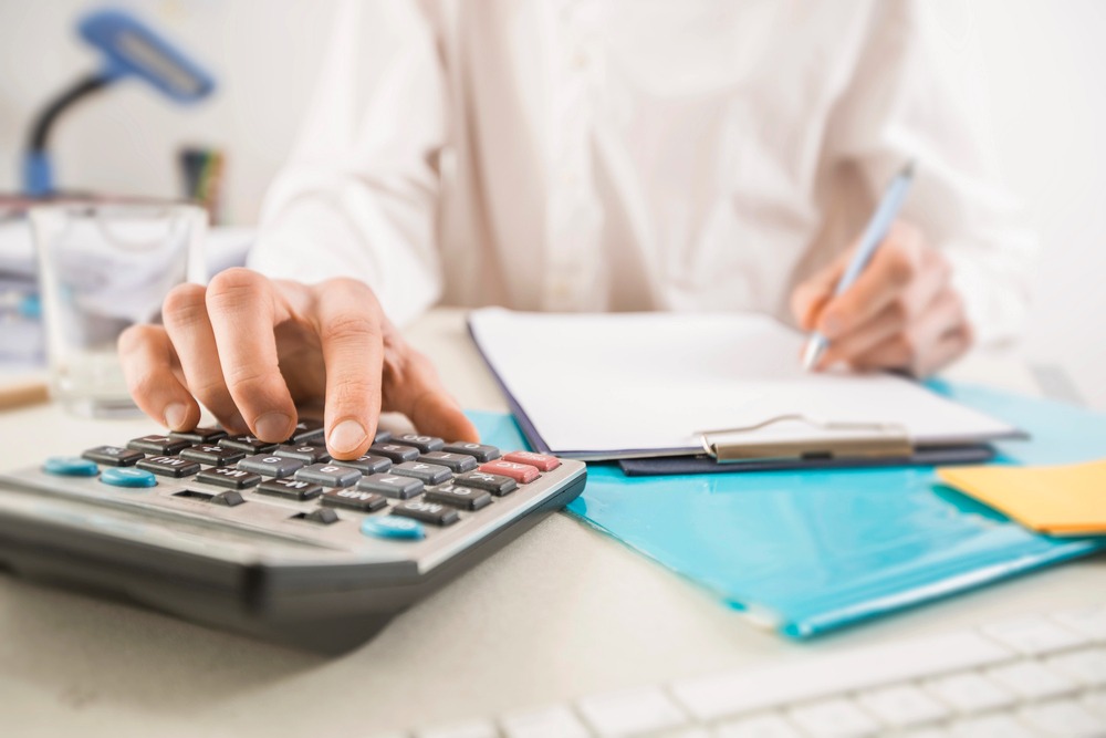 person sitting at desk with calculator for estate tax planning