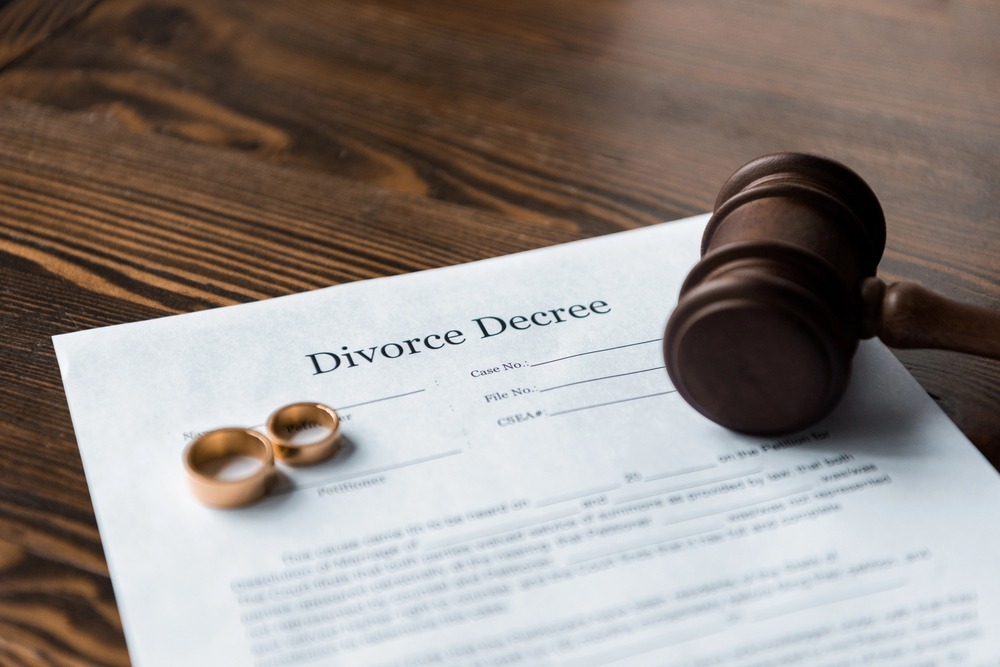 divorce decree with wedding rings and a judge's gavel representing legal strategies for protecting assets during divorce proceedings