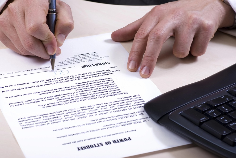 person signing power of attorney document as a part of estate planning for unmarried couples